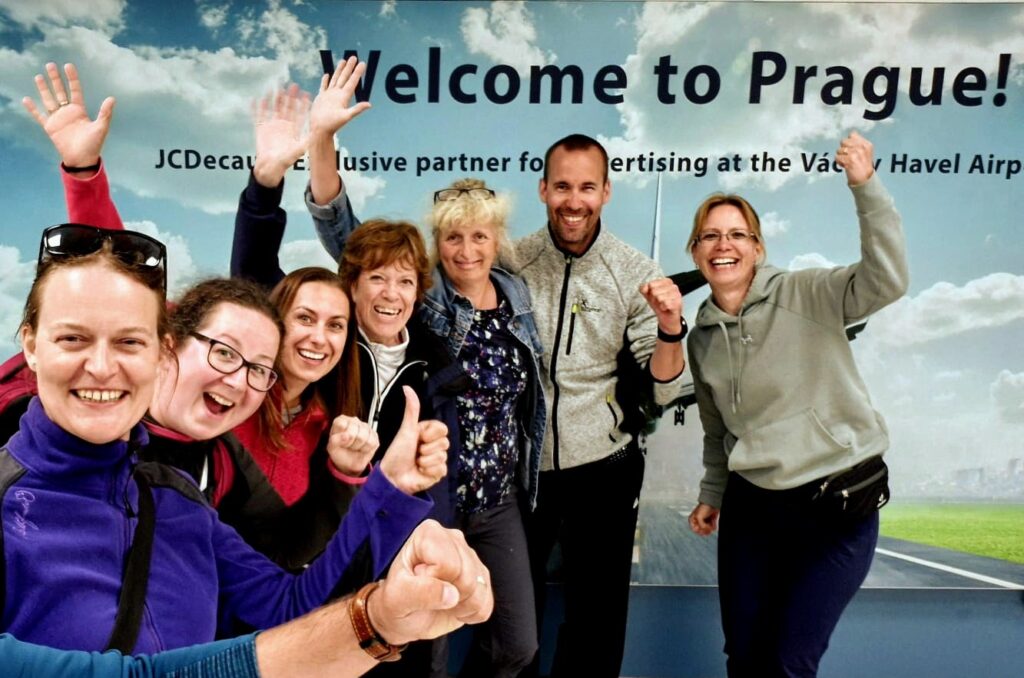 Happy travelers arriving at Prague Airport, greeted by their private driver-guide from Europe With Zuzana.